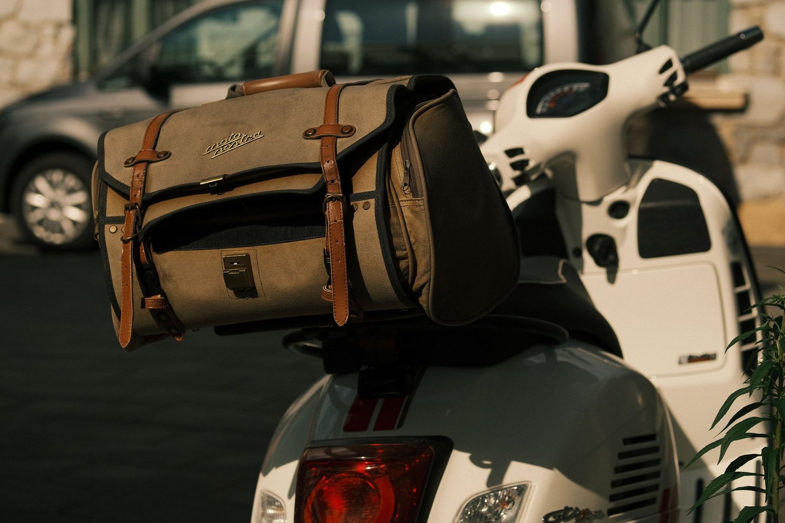 Sac de voyage attaché au porte-bagages arrière d’un scooter, prêt à partir dès l’arrivée à Ibiza