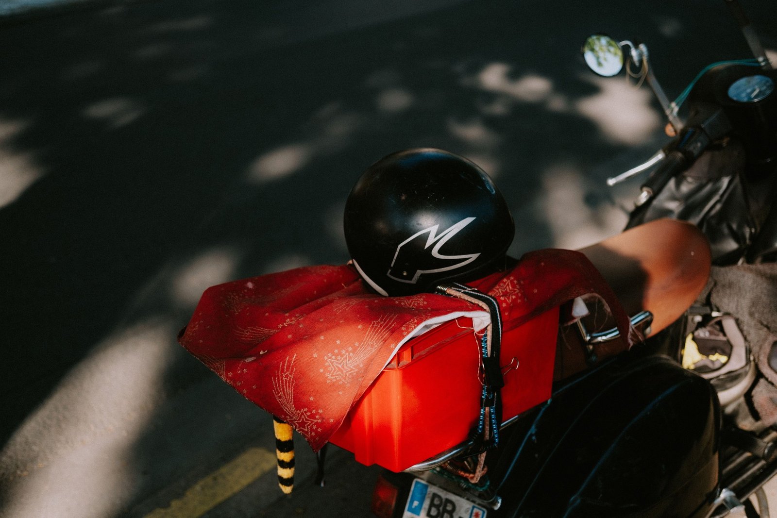 Motorradhelm auf dem Gepäck eines in der Sonne geparkten Rollers, so wie bei der Abholung direkt nach der Ankunft auf Menorca